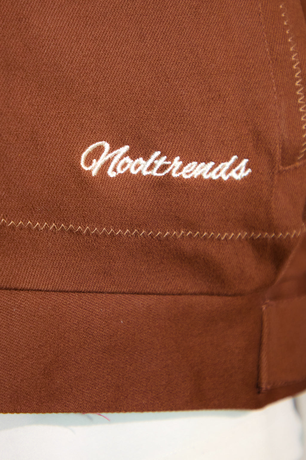Nooltrends embroidered on the Mocha Palmeraie jacket for subtle branding